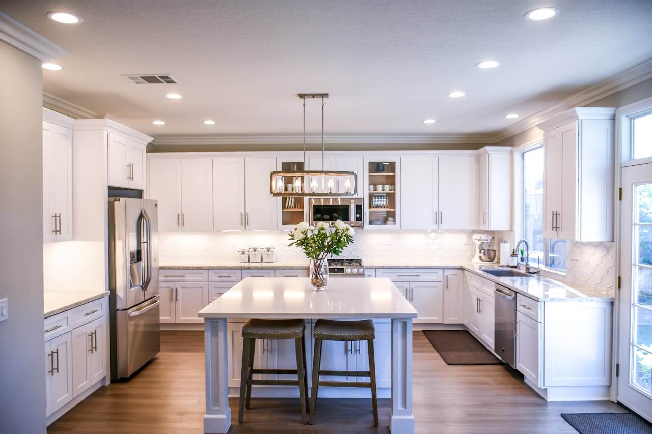 Modern kitchen remodel in Denver Colorado with white cabinets, quartz countertops, center island seating, and recessed lighting